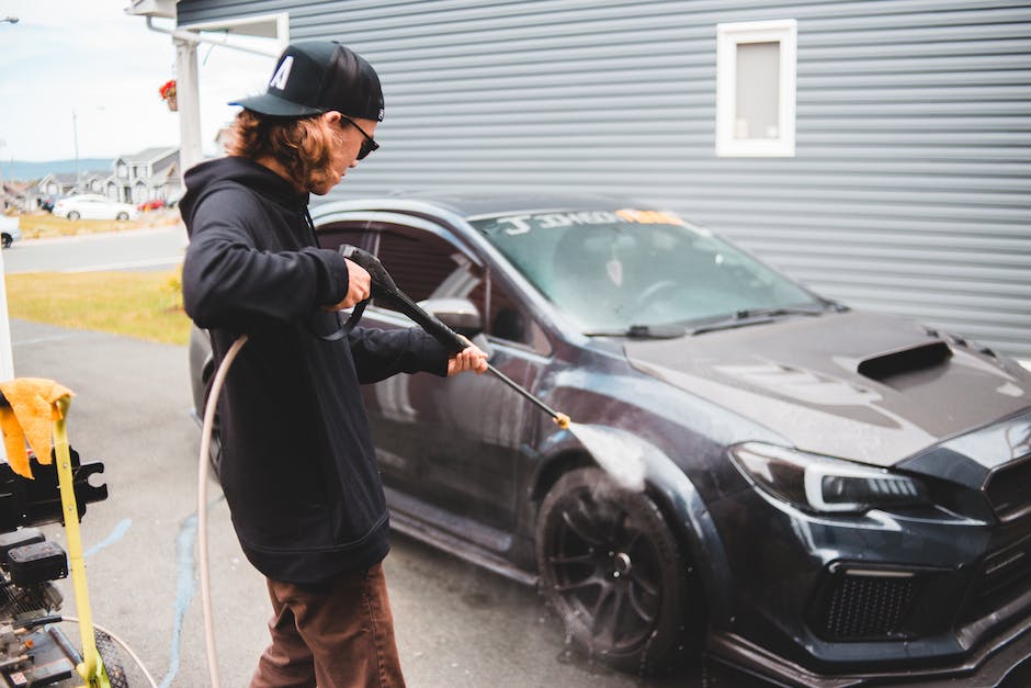 A professional technician carefully cleaning a car's exterior, showcasing the importance of car care.
