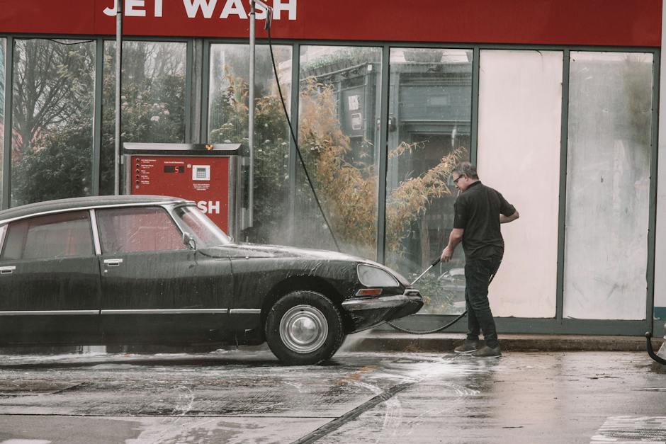 A vintage car being carefully washed by a professional car care specialist